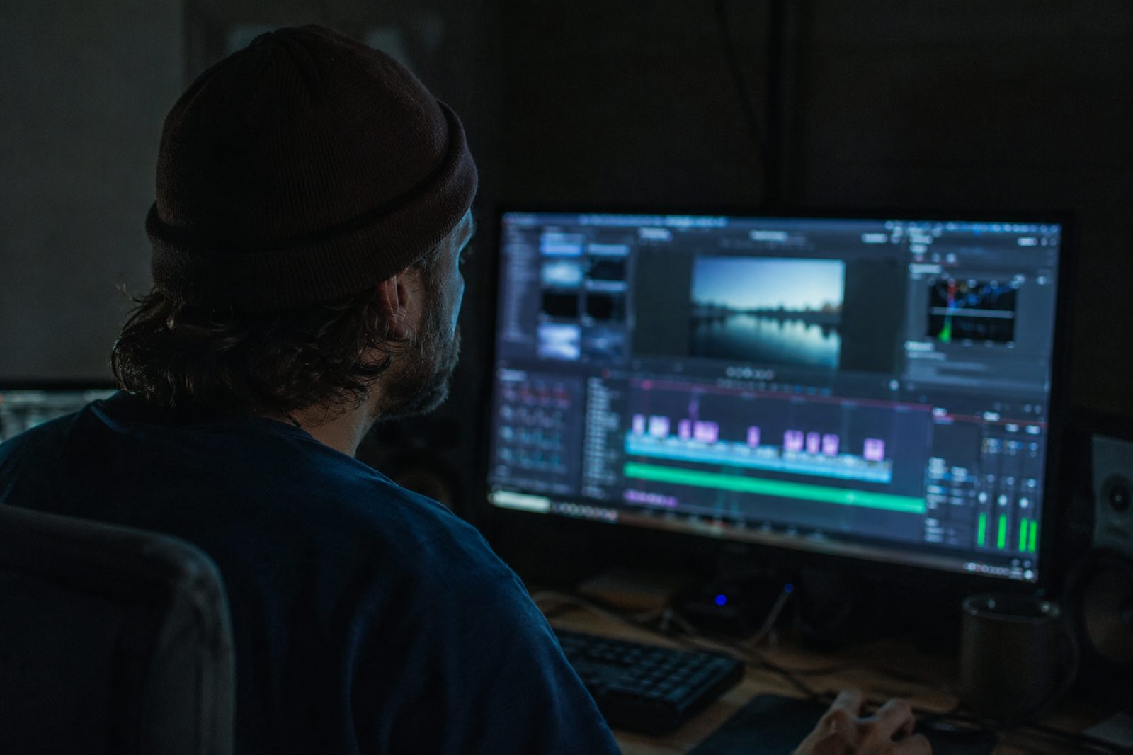 Video editor working at an editing timeline, concentrating on a cut